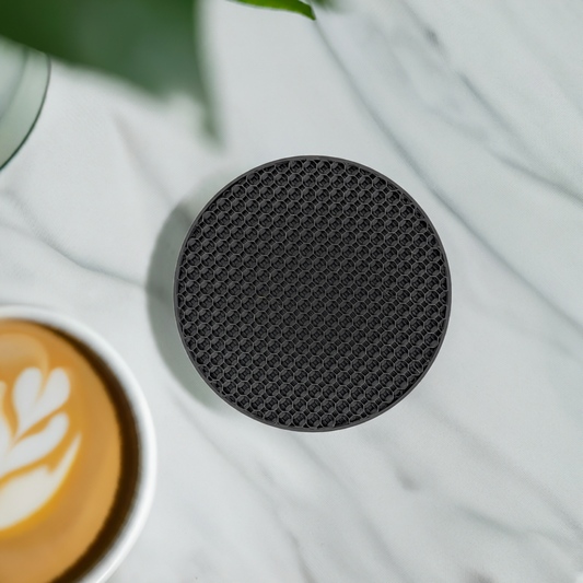 AI generated image of a black 3d honeycomb pattern infill coaster on a marble surface next to a coffee cup