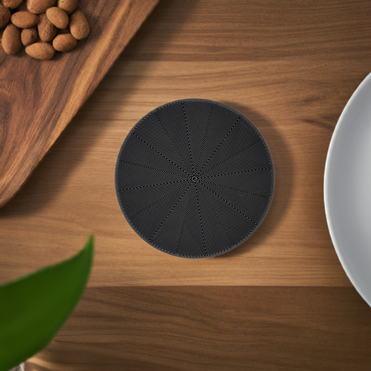 AI generated image of a black star spiral infill coaster on a light wood surface next to a plate