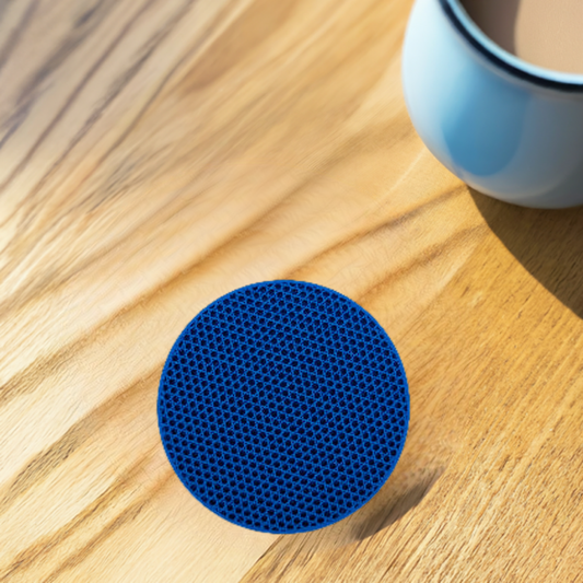 AI generated image of a blue tri-hexagon infill coaster on a light wood surface next to a coffee cup