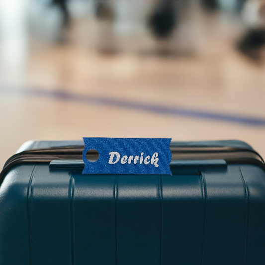 AI generated image of a large blue and white customizable name plate resting on a suitcase
