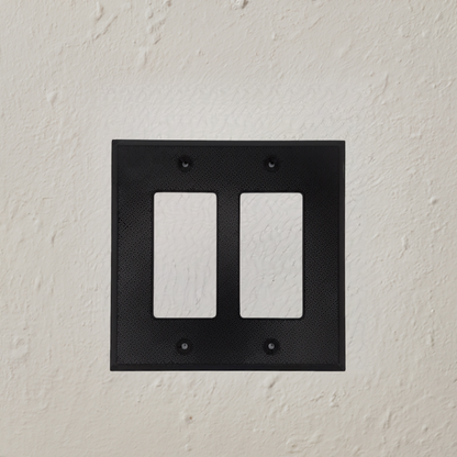 AI generated image of a black double light switch cover on a textured wall