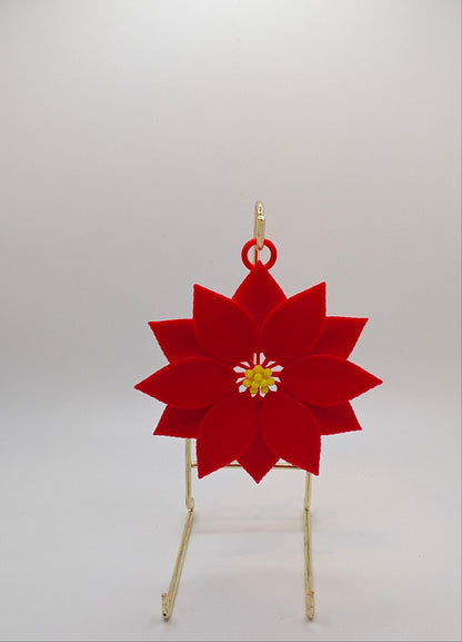Red poinsettia flower ornament on a stand against a white background