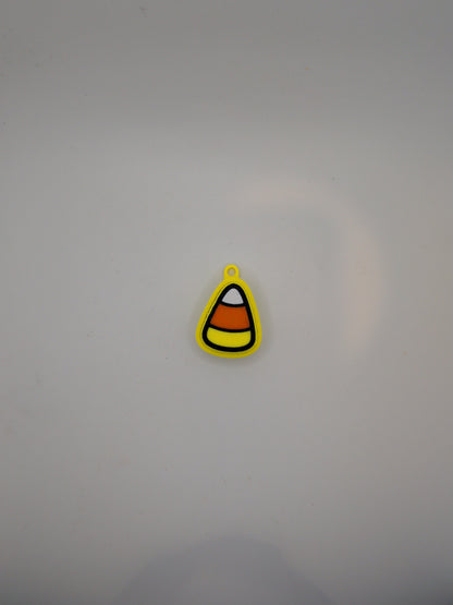 A small candy corn-shaped fidget toy with yellow, orange, white, and black stripes, shown on a plain light gray background.